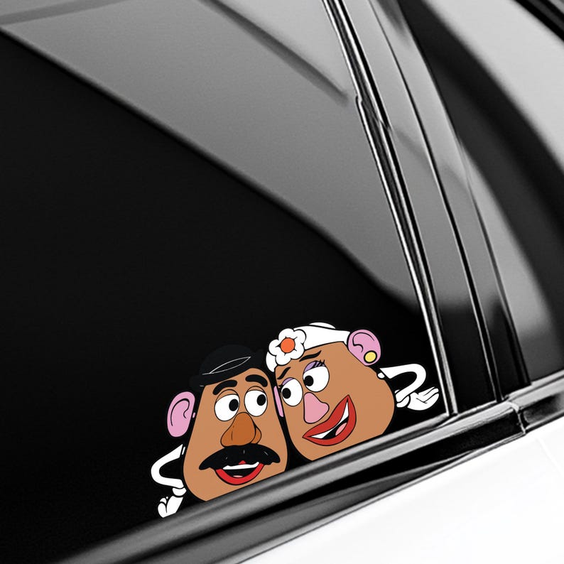 May include: A car decal featuring a cartoon couple with brown skin, large eyes, and smiling red lips. The male character has a black mustache and hat, while the female character wears a white headband with a flower.
