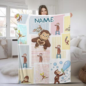 May include: A colorful blanket featuring a repeating pattern of a cartoon monkey in various poses. The blanket has a patchwork design with stripes and solid colors, and the word "NAME" is printed in large letters.