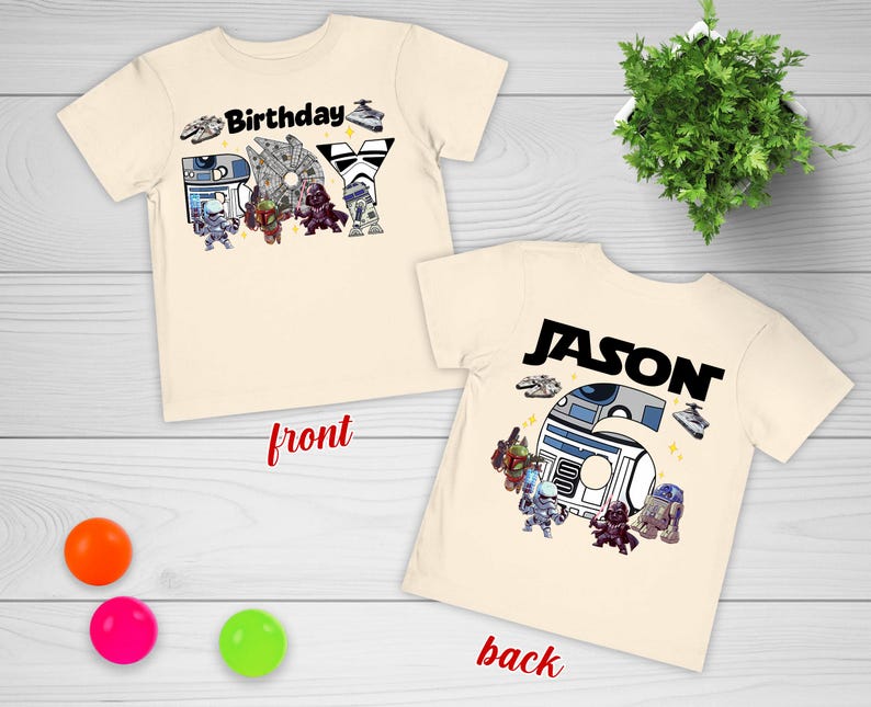 May include: Two cream-colored t-shirts with a Star Wars theme. One shirt says "Birthday Boy" with character graphics. The other shirt says "Jason" with character graphics. The shirts are on a light wood surface.