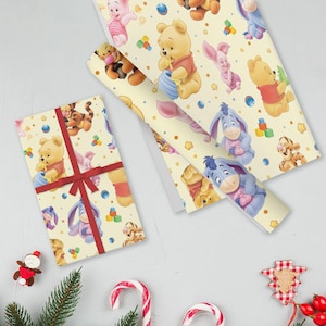 May include: Gift-wrapped present and rolls of wrapping paper featuring Winnie the Pooh and friends on a cream background. The gift is tied with a red ribbon. Additional holiday decorations are scattered around the gift.