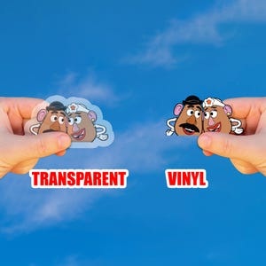 May include: Two stickers featuring cartoon potato characters, one transparent and one vinyl. The transparent sticker has the word "TRANSPARENT" in red. The vinyl sticker has the word "VINYL" in red. Both stickers are held against a blue sky background.
