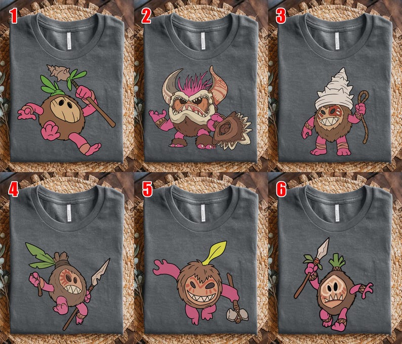 Puede incluir: Seis camisetas grises con dise&ntilde;os de personajes de dibujos animados. Cada camiseta presenta una criatura diferente con acentos rosas, marrones y verdes. Las criaturas est&aacute;n representadas con varios accesorios. Las camisetas se muestran sobre una superficie tejida.