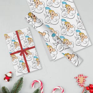 May include: White wrapping paper featuring a repeating pattern of cartoon characters on clouds. A wrapped gift with a red ribbon and a roll of matching paper are visible. Festive holiday decorations are in the foreground.