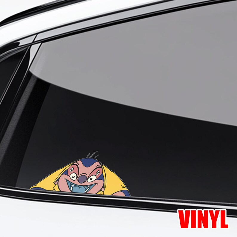 May include: A vinyl decal featuring a cartoon character with blue skin, a yellow shirt, and an angry expression. The decal is applied to a car window, with the word "VINYL" in red at the bottom.