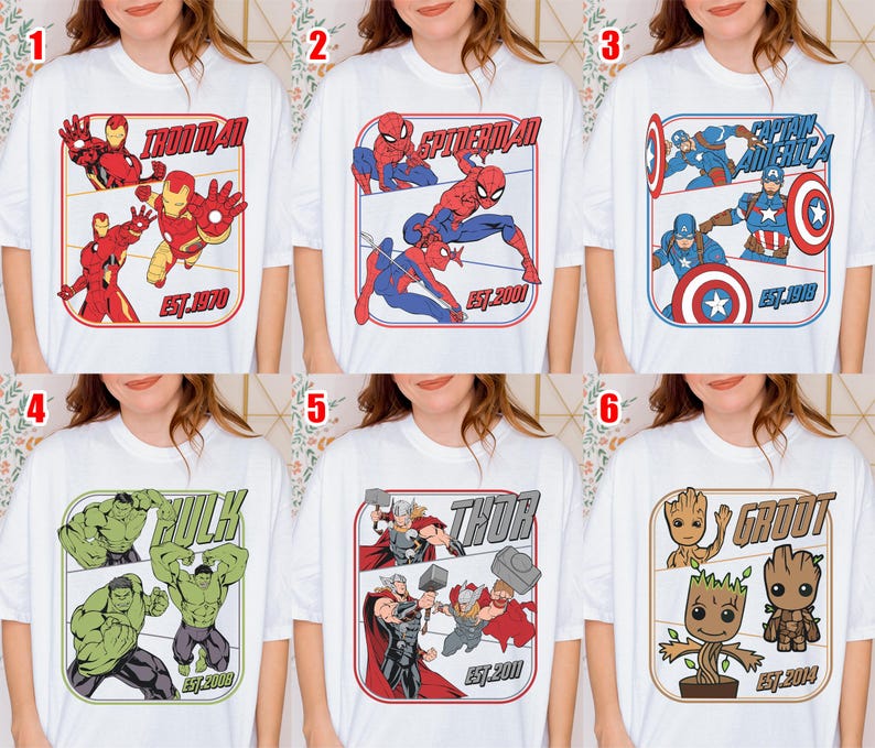 K&ouml;nnte beinhalten: Wei&szlig;e T-Shirts mit verschiedenen Marvel-Superhelden: Iron Man, Spider-Man, Captain America, Hulk, Thor und Groot. Jedes Design enth&auml;lt den Namen der Figur und ein Gr&uuml;ndungsjahr in einem rechteckigen Rahmen.