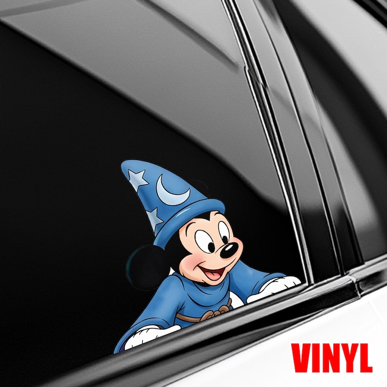 Puede incluir: Una calcoman&iacute;a de vinilo con Mickey Mouse vestido de hechicero, con un sombrero azul adornado con estrellas y una luna creciente. Mickey sonr&iacute;e y lleva una t&uacute;nica azul. La palabra "VINYL" est&aacute; en rojo.