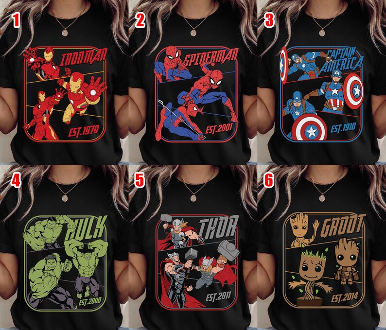 K&ouml;nnte beinhalten: Schwarze T-Shirts mit Marvel-Superhelden: Iron Man, Spider-Man, Captain America, Hulk, Thor und Groot. Jedes Design zeigt den Namen der Figur und das Erscheinungsjahr in einem rechteckigen Rahmen.