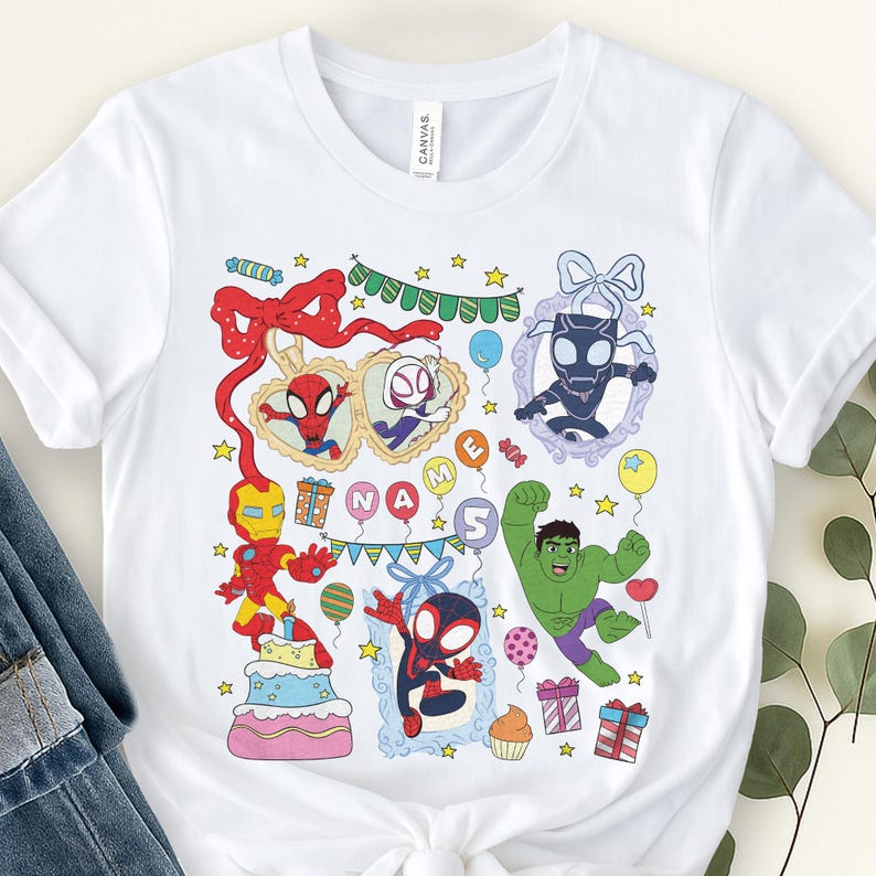 May include: A white short-sleeve t-shirt featuring a colorful graphic print of various superheroes, including Iron Man, Hulk, and Spider-Man characters. The design includes birthday-themed elements like balloons, gifts, a cake, and the text NAME.