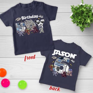May include: Navy blue short-sleeved t-shirt with a Star Wars theme. The front features the word "Birthday" and various characters. The back has the name "JASON" and the number "6".