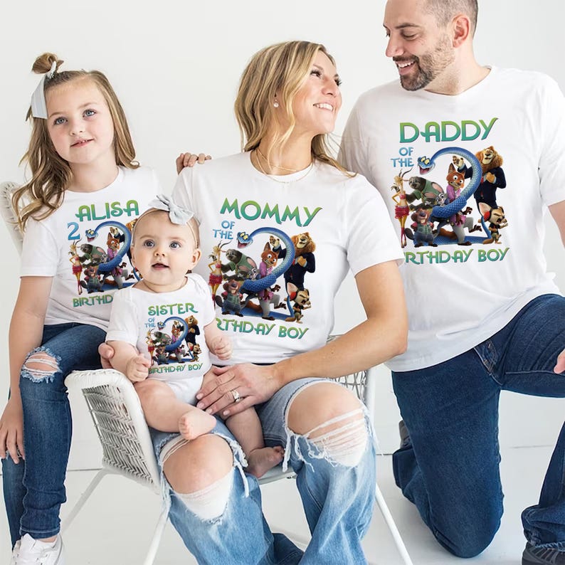 May include: White t-shirts with matching graphics and text for a family. The shirts feature a blue number 2 with cartoon characters and the phrases "ALISA 2 BIRTHDAY BOY", "MOMMY OF THE BIRTHDAY BOY", "SISTER OF THE BIRTHDAY BOY", and "DADDY OF THE BIRTHDAY BOY".