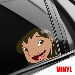 May include: A vinyl decal featuring a cartoon girl's face, smiling with a red mouth and brown hair. The decal is visible through a car window. The word "VINYL" is printed in red at the bottom.