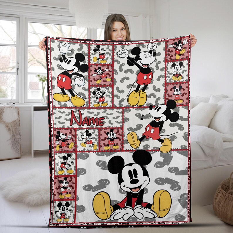 May include: A white blanket featuring a repeating pattern of Mickey Mouse in various poses, with red and black accents. The blanket has a red border and a section with the name "Name" in a script font. The background has gray Mickey Mouse shapes.