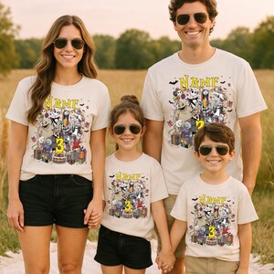 Pode incluir: T-shirts bege com um gr&aacute;fico de desenho animado colorido com personagens, presentes e um bolo de anivers&aacute;rio. As camisas t&ecirc;m a palavra "NAME" acima do gr&aacute;fico e um n&uacute;mero abaixo. A fam&iacute;lia est&aacute; usando &oacute;culos de sol.