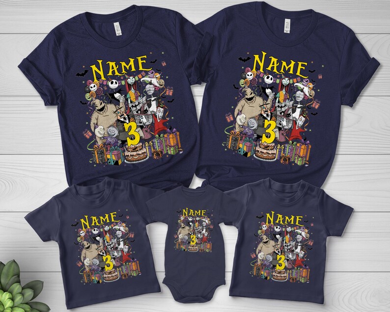 Pode incluir: T-shirts azul marinho com um gr&aacute;fico colorido com personagens, o n&uacute;mero 3 e o nome "Name". O design inclui um bolo de anivers&aacute;rio e presentes embrulhados. As camisas est&atilde;o dispon&iacute;veis em v&aacute;rios tamanhos.