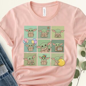 May include: A pale pink t-shirt with a grid of nine cartoon images of a green alien-like character. Each image shows the character in different poses, some holding balloons or a yellow ball. The shirt has a 'Canvas' tag.