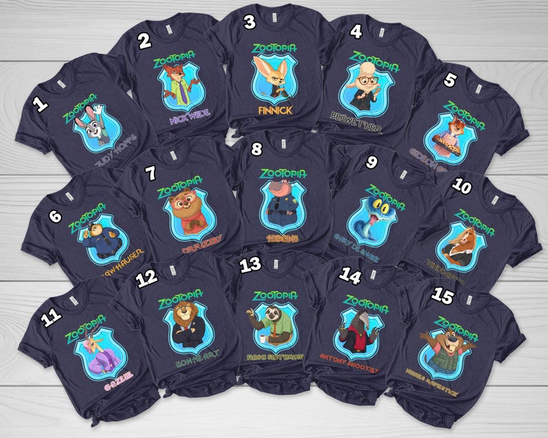 Op de afbeelding: Een collectie van vijftien donkerblauwe t-shirts, elk met een Zootopia-personage in een lichtblauw schildvormig embleem. De shirts zijn genummerd van &eacute;&eacute;n tot vijftien en tonen namen zoals Judy Hopps, Nick Wilde en Flash.