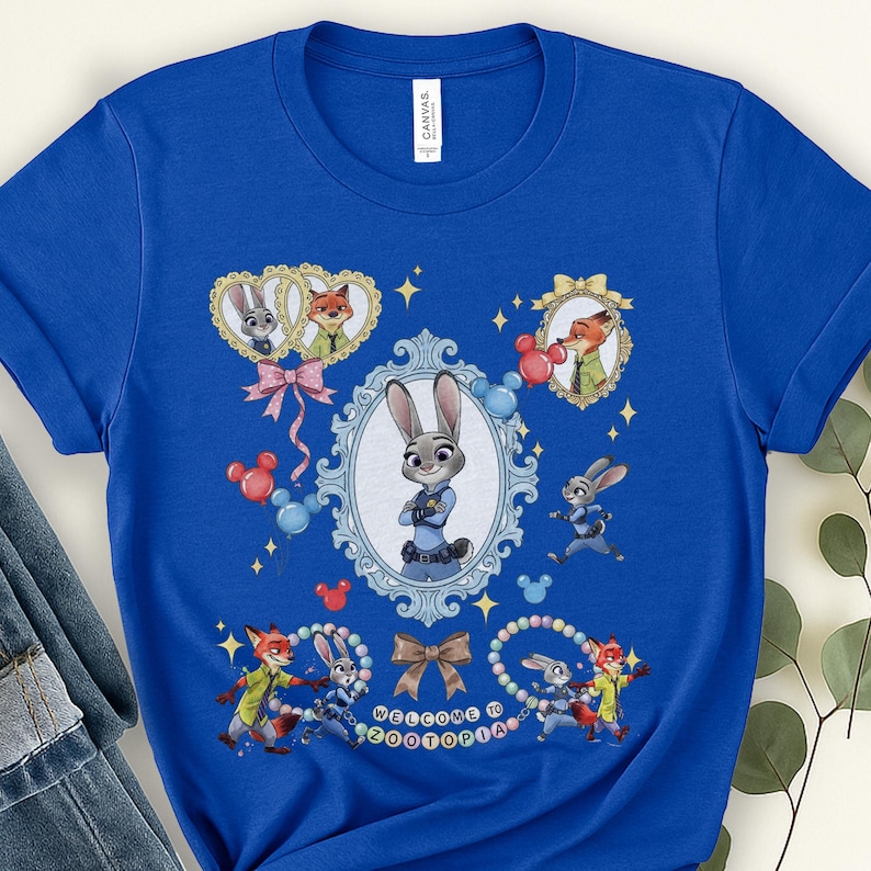 May include: A royal blue t-shirt featuring a colorful graphic design from the movie Zootopia. The design includes images of Judy Hopps and Nick Wilde, along with the text "Welcome to Zootopia". The shirt has short sleeves and a crew neck.