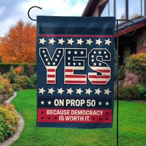 May include: A navy blue garden flag with the word "YES" in a distressed font, filled with a pattern of red and white stripes and white stars. The flag also includes the text "ON PROP 50" and "BECAUSE DEMOCRACY IS WORTH IT."