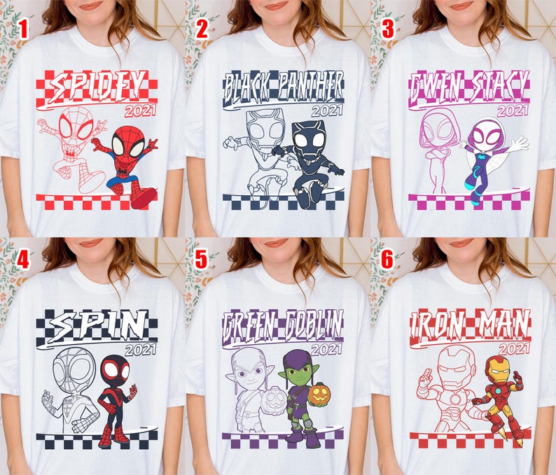 May include: White t-shirts featuring superhero designs. The shirts display graphics of "Spidey," "Black Panther," "Gwen Stacy," "Spin," "Green Goblin," and "Iron Man," each with "2021" text. The illustrations are in red, black, and blue.