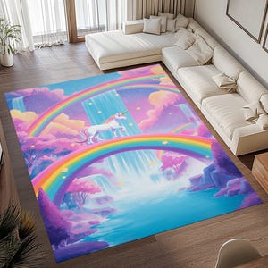 May include: A rectangular rug with a fantasy scene featuring a white unicorn, rainbows, and waterfalls. The rug's colour palette includes blue, pink, and purple. The unicorn stands on a rainbow, creating a magical atmosphere.