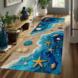 Puede incluir: Una alfombra rectangular tipo pasillero con un diseño costero que muestra una orilla de arena beige que se transforma en olas de océano azul profundo. La superficie está decorada con varias conchas marinas dispersas y estrellas de mar.