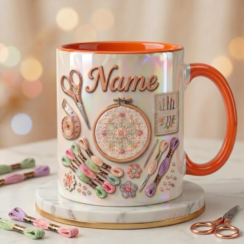 May include: A ceramic mug with an iridescent finish and a bright orange handle and interior. The exterior features the word Name in script, surrounded by illustrations of embroidery supplies including scissors, a measuring tape, a hoop, and thread.
