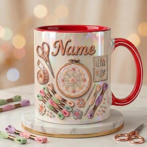 May include: A white iridescent ceramic mug with a red interior and handle, featuring a printed design of embroidery supplies including scissors, a measuring tape, an embroidery hoop, needles, and colorful thread skeins with the text Name.