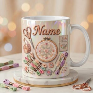 May include: A white iridescent ceramic mug featuring a central embroidery hoop with floral stitching, surrounded by sewing scissors, a measuring tape, needle case, and colorful embroidery floss skeins. The word Name is printed in gold script.