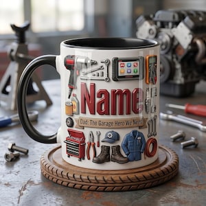 May include: White ceramic mug with a black handle and rim, decorated with mechanic tools and the name "Name" in red 3D letters. The mug includes the text "Dad: The Garage Hero We Need". It sits on a wooden coaster.