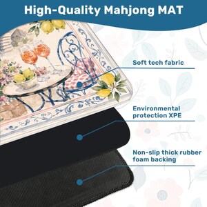May include: A rectangular mahjong mat featuring a watercolor illustration of a table with two glasses of orange liquid and a bowl of lemons. The mat is composed of three layers: a soft tech fabric top, an environmental protection XPE core, and a non-slip thick rubber foam backing.