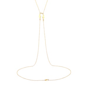 Puede incluir: Un collar de cadena de oro con dos dijes decorativos en la parte superior y un cierre de langosta.
