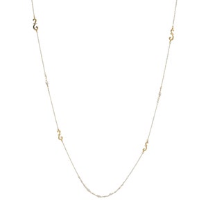Puede incluir: Un collar de cadena de oro con una serie de peque&ntilde;os colgantes en forma de 'S' estilizados.