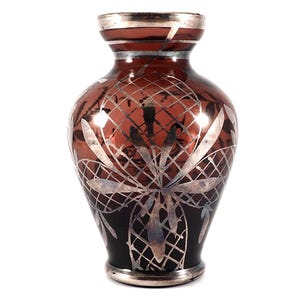 May include: A dark purple glass vase with a silver floral design. The vase has a round body and a narrow neck.