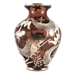 May include: A brown glass vase with a silver overlay of a dragon design. The vase has a round body and a narrow neck.