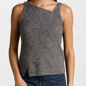 May include: A gray sleeveless top with a unique asymmetrical design. The top features a ribbed texture and a split hem. The model is wearing dark blue jeans. The top is made of a soft, comfortable material.