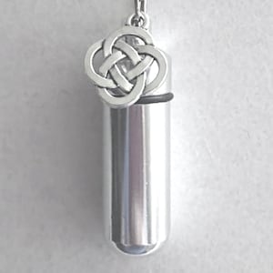 May include: Silver necklace with a silver Celtic knot pendant and a silver cylindrical urn charm.