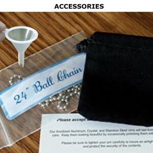 May include: Accessories set including a small white funnel, a 24-inch ball chain necklace, and a black velvet pouch. The text "24" Ball Chain" is visible on a blue and white label. The word "ACCESSORIES" is at the top.