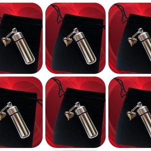 May include: Ten silver cremation urns with a small heart charm. Each urn is in a black velvet pouch.