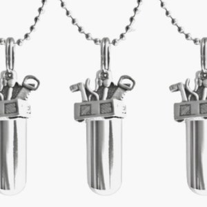 May include: Five silver necklaces with a pendant shaped like a toolbox with tools inside. Each necklace has a silver chain.