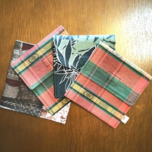 Peut inclure: Plusieurs portefeuilles en tissu aux motifs variés. L'un présente un motif à carreaux rouges, verts et jaunes. Un autre a un fond vert foncé avec des accents floraux blancs. Les autres ont un mélange de motifs.