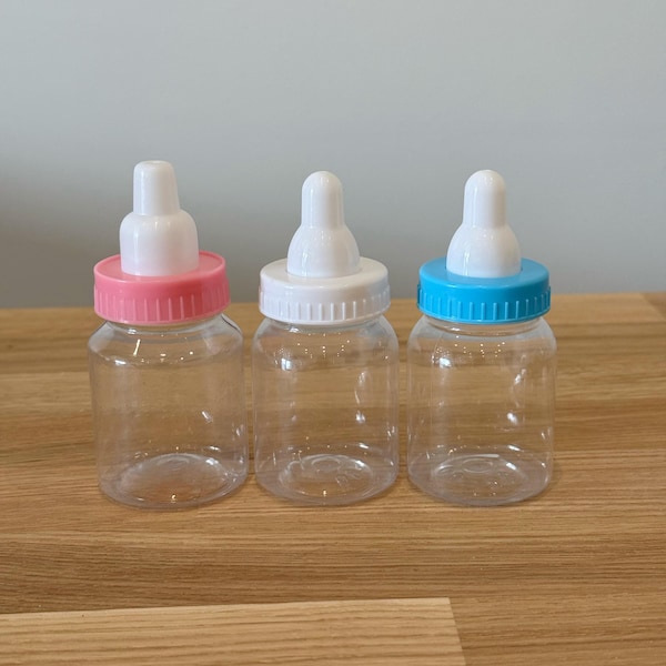 May include: Three clear plastic baby bottles with white nipples and colored lids. The lids are pink, white, and blue.