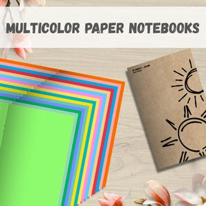 May include: A stack of colorful paper notebooks with the text "MULTICOLOR PAPER NOTEBOOKS" at the top. A brown notebook with sun illustrations is on the right. The paper colors include green, blue, yellow, orange, and red.