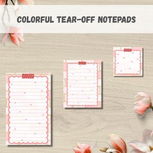 May include: Colorful tear-off notepads in various sizes. The notepads have a pink scalloped border and are lined with pink lines. The text "Colorful Tear-Off Notepads" is at the top. The notepads are taped to a light wood surface.