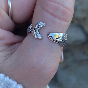 Peut inclure: Bague en argent avec un motif de poisson détaillé. L'œil du poisson est un petit accent rond en or.