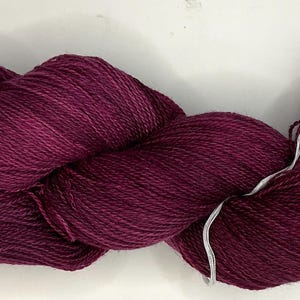 May include: A skein of deep purple yarn with a subtle color variation.
