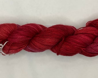 May include: A skein of red, pink, and purple yarn with a silver yarn needle.