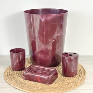 Vintage red marble bathroom set with glass bin, soap dish, and toothbrush holder; retro decor