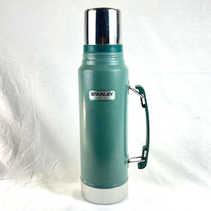 Termo Stanley Classic Green con asa y tapa tipo taza, de acero inoxidable, para bebidas frías y calientes, 1 cuarto de galón.