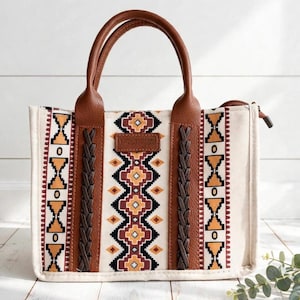 Peut inclure: Un sac fourre-tout rectangulaire doté d'un corps en toile couleur crème avec un motif géométrique noir, marron et orange. Le sac comprend des poignées en similicuir marron, deux accents tressés verticaux marron et une étiquette de marque rectangulaire marron.