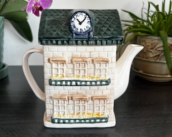 Vintage ceramic house teapot shaped like a building with roof clock – whimsical kitchen decor or collectible novelty teapot